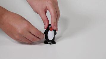 Hands wind up a penguin toy video