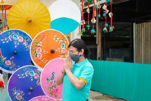 A man wearing a mask and holding an umbrella photo