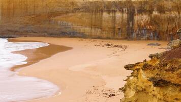 Waves gently lap against sandy cliffs video
