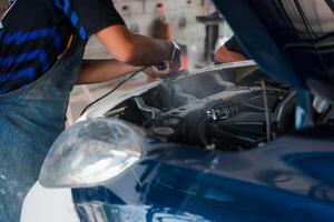 A man is working on a car engine photo