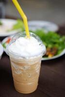 Ice latte shake coffee with whipped cream in plastic glass with traditional Thai food photo