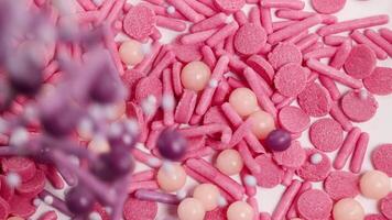 Macro of vibrant candies transitioning from pink to purple hues, showcasing a dynamic and colorful visual experience video