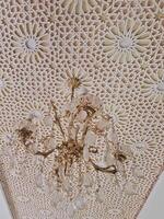 A breathtaking chandelier adorns the ceiling, boasting intricate patterns and geometric motifs, expertly crafted from gypsum to create a masterpiece that harmoniously fuses tradition and modernity. photo