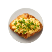 Delicious croissant topped with fluffy scrambled eggs and fresh herbs served on a plate png