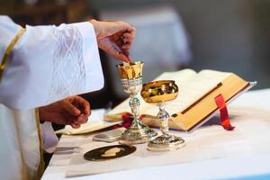 Priest draws consecrated host in wine for Eucharist photo