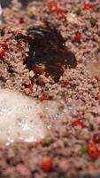 Ground beef is stir-fried with peppers and sauce in a kitchen setting. Close-up shots highlight the cooking process video