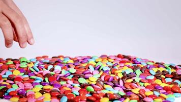 Hands sorting and dropping colorful candies video