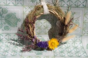 Handcrafted wreath made from dried flowers and herbs, showcasing unique colors and textures, perfect for seasonal decoration in home or celebration space photo
