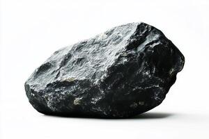 A single dark gray rock with rough texture on a white background in a studio setting view photo