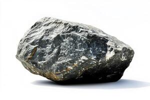 A single large gray rock with rough texture sitting on a white surface under bright light photo