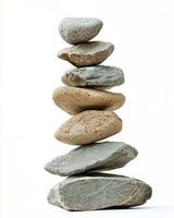 A stack of seven smooth stones balanced on top of each other against a white background photo