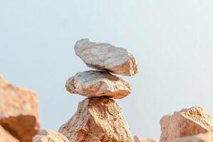 A stack of rocks balancing against a light blue sky in an outdoor setting, zen concept art photo