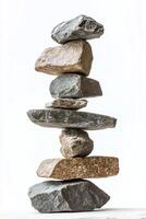 A vertical stack of various sized and colored rocks balanced on top of each other on white photo