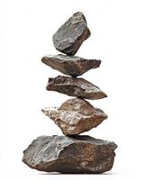 A stack of five gray rocks balanced on top of each other against a white background studio shot photo