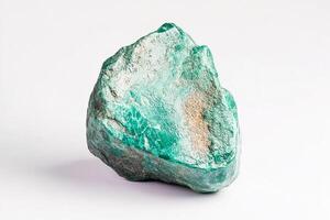 Close up shot of a rough malachite stone specimen against a plain white background surface photo