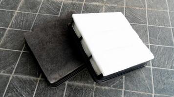 Old and new filters are stacked clearly on top of each other. Placed on a black tiled floor. photo