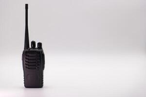 Walkie talkie resting on a surface with simple background highlighting its features and design photo
