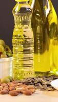 A variety of healthy fats including oils, nuts, and avocados arranged on a table with soft lighting video