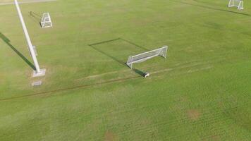 A remote-controlled robot paints precise lines on a soccer field under bright daylight, showcasing automation in sports field maintenance video