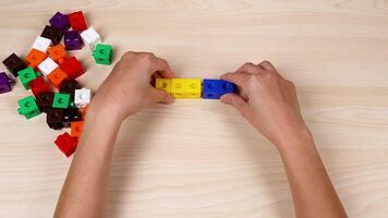 Hands assembling colorful cubes on a table video