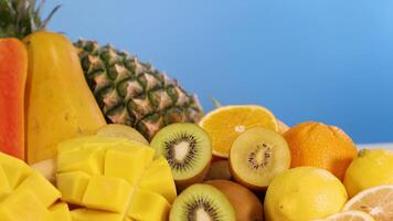 Assorted fruits arranged against a blue background video