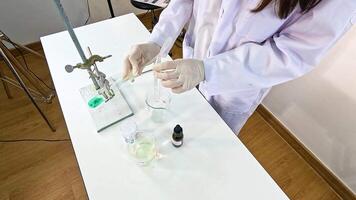 A scientist conducts a chemical reaction between copper carbonate and sulfuric acid in a controlled laboratory setting video