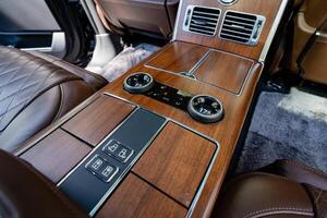 Experience the elegance of a luxury car interior featuring a beautifully crafted wooden console along with stateoftheart climate controls designed for ultimate comfort and convenience photo