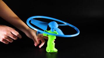 Hands operate a pull string flying toy video