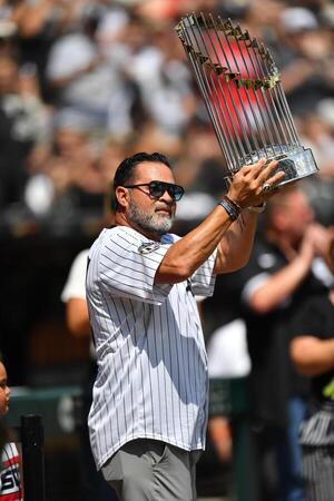 Ozzie Guillen, member of the 2005 World Series Chicago White Sox walks out with the Commissioner's Trophy prior to a game against the Cleveland Guardians at Rate Field. editorial_image