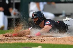 Cleveland Guardians catcher Austin Hedges (27) slides into home plate to score during the seventh inning against the Chicago White Sox at Rate Field. editorial_image
