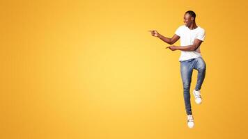 Man pointing against yellow background photo
