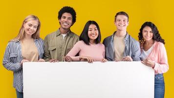 Education, ad and student recommendations. Diverse teens cheerful international students holding big banner with free space and ready to study at college, isolated on beige background, studio shot photo