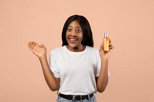 Woman holding skincare product with a smile photo