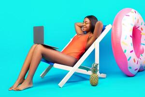 Relaxed black lady chilling in lounge chair with laptop computer, communicating online from tropical paradise, watching good movie on summer vacation, blue studio background. Copy space photo