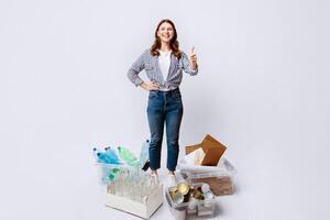 Sustainability Concept. Cheerful Millennial Woman Standing Next To Containers With Different Materials For Recycling And Showing Thumb Up At Camera,Happy Eco-Activist Lady Enjoying Sorting Garbage photo