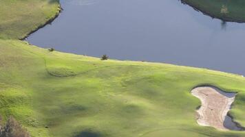 Drone footage captures serene golf course with lush greens, water hazards, and tree shadows under soft daylight in Gold Coast, Australia video