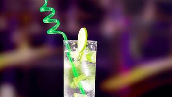 A vibrant mojito cocktail with lime and a spiraling straw in a lively, colorful setting. Bright lighting enhances the refreshing mood video