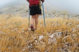 Hiker Walking Through Foggy Mountain Trails with Trekking Poles photo
