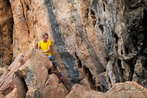Climber on rocky terrain in yellow shirt photo