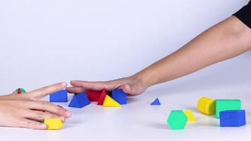 Hands organizing colorful geometric shapes on table video