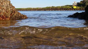 Waves gently crashing against rocky shore video
