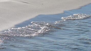 Waves gently lap against a sandy shore video