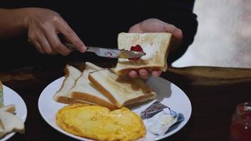 Spreading jam on buttered toast over time video