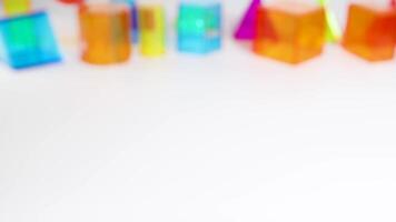 Hands interact with vibrant geometric shapes on a white table, highlighting educational play with colorful prisms and spheres video