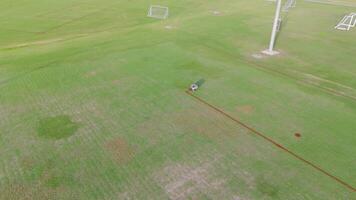 A remote-controlled robot paints precise lines on a soccer field under bright daylight video