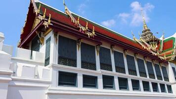 A dynamic view of the Temple of the Emerald Buddha in Bangkok, showcasing its intricate architecture under clear blue skies video