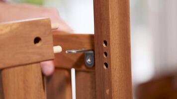 Hands assembling wooden furniture using dowel joints in a well-lit indoor setting. Close-up shots highlight precision and craftsmanship video