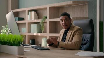 Lazy businessman African American business man play online game with controller playing console take break at office pretend working funny worker fooling hiding joystick under table gaming addicted video