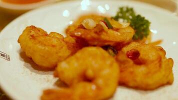 Golden fried shrimp on a white plate with garnish, captured in warm lighting at a Gold Coast restaurant video