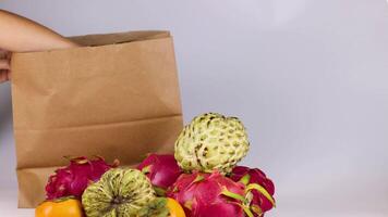 Hands placing fruit into a paper bag video